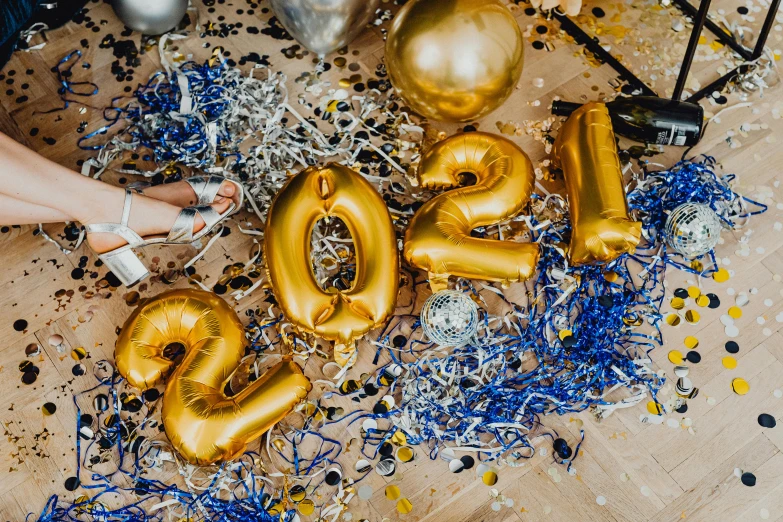 a table topped with gold balloons and confetti, by Julia Pishtar, trending on pexels, happening, golden blue outfit, 21 years old, bubble letters, post graduate