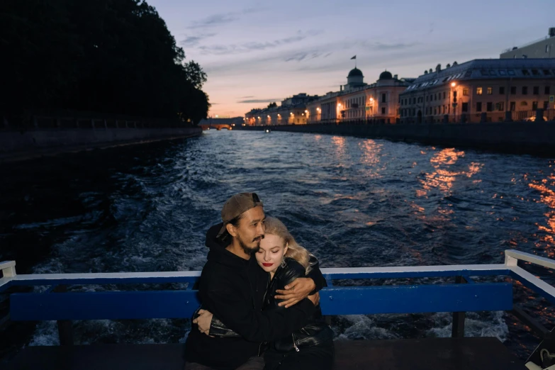 a man and woman sitting next to each other on a boat, by Julia Pishtar, pexels contest winner, symbolism, russian girlfriend, elle fanning at night, river in the background, hugs