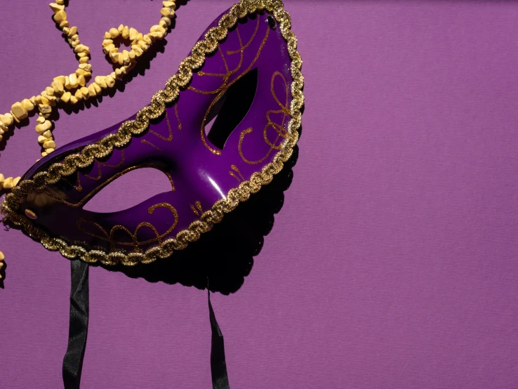 a purple mask sitting on top of a purple table, pexels contest winner, renaissance, background image, carnival background, canvas, high angle close up shot