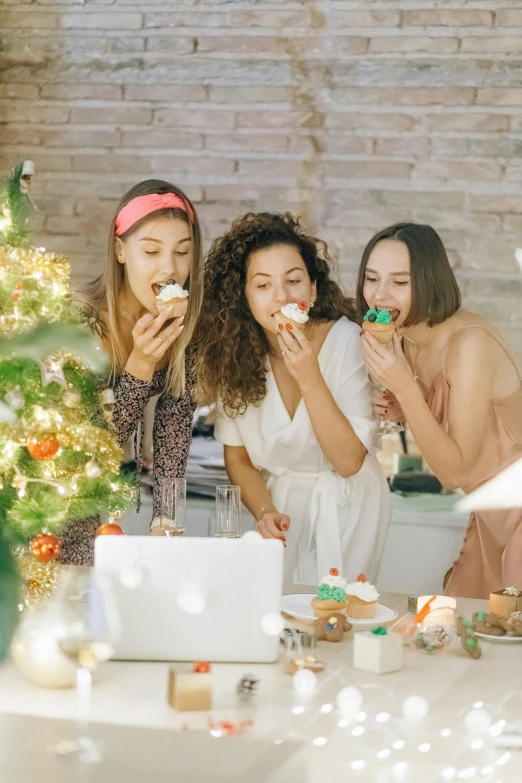 a group of women standing in front of a christmas tree, pexels contest winner, eating cakes, 3 young and beautiful women, cupcake, gaming