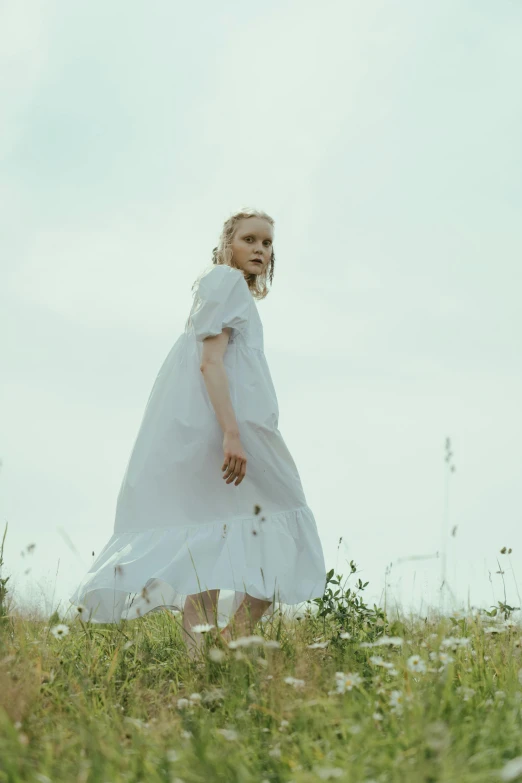 a woman in a white dress walking through a field, looks a blend of grimes, with a white complexion, press shot, promotional image