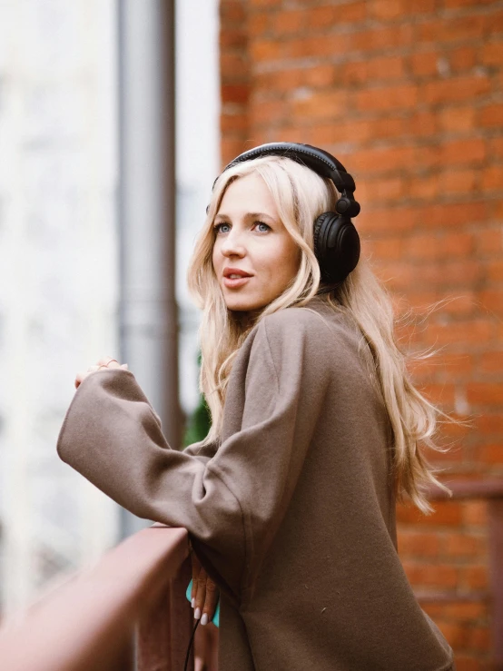 a woman wearing headphones leaning on a railing, by Julia Pishtar, black and brown colors, thumbnail, lossless quality, nordic noire