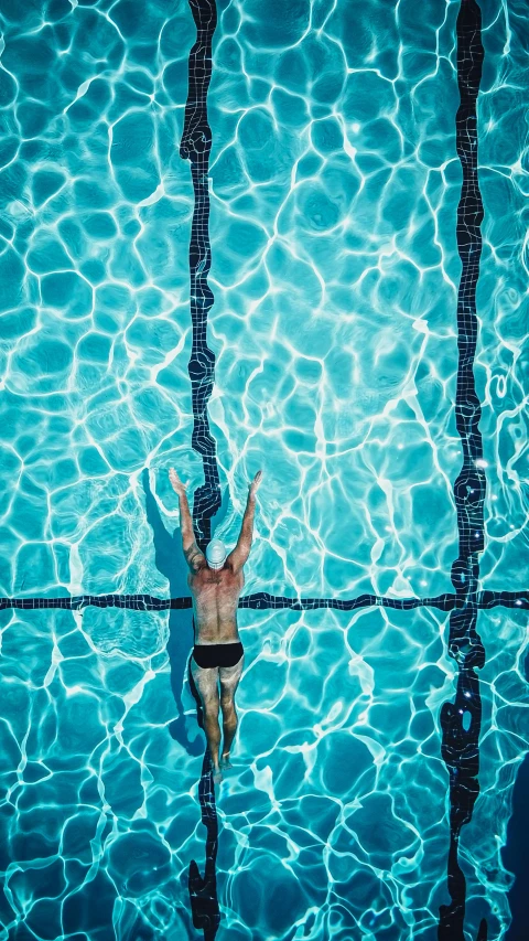 a person swimming in a pool of water, by Carey Morris, pexels contest winner, olympic diving springoard, top - down photograph, 268435456k film, thumbnail