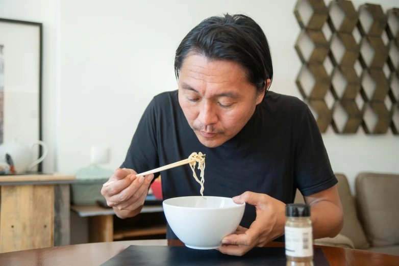 a man eating a bowl of noodles with chopsticks, a portrait, shin hanga, profile image, damien tran, seated at a table, dripping blue natural iwakura