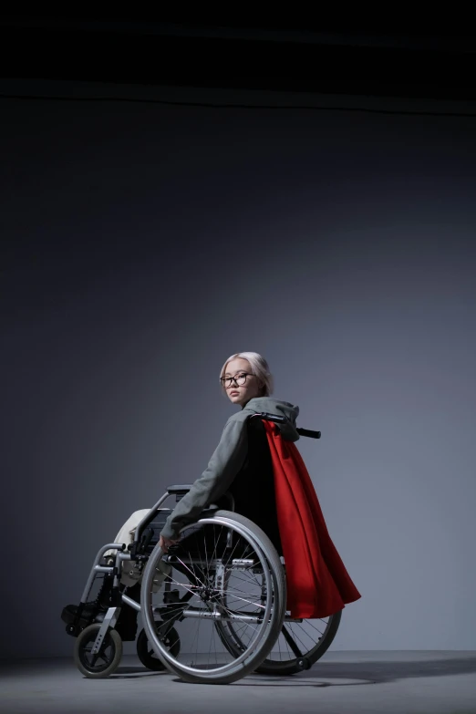 a man in a wheelchair with a red cape, an album cover, featured on zbrush central, altermodern, maika monroe batgirl, photographed for reuters, renderman, modeled