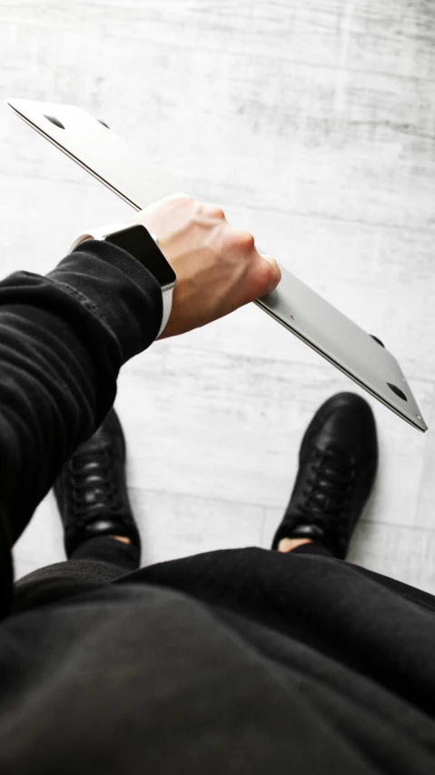 a close up of a person holding a laptop, an album cover, inspired by Alexander Kanoldt, unsplash, holding a kitchen knife, shungite bangle, posing ready for a fight, grey