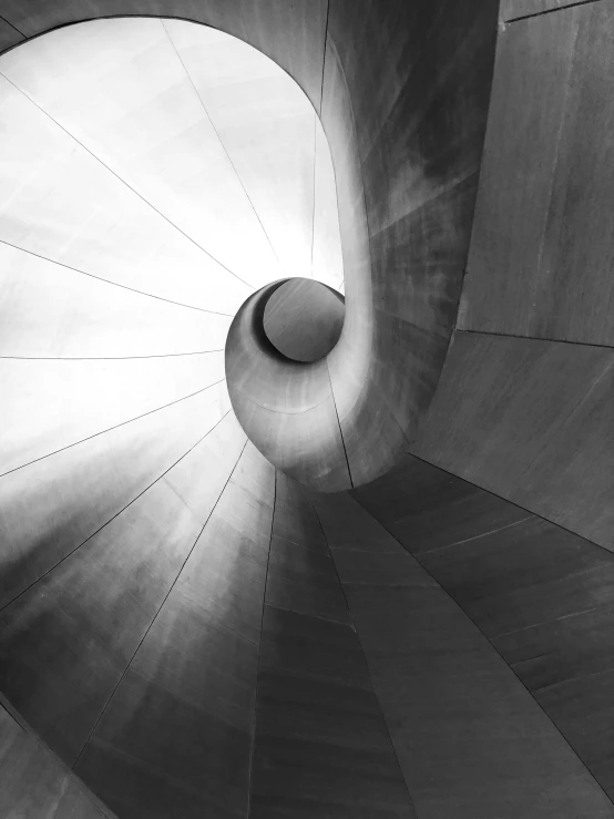 a black and white photo of a spiral staircase, an abstract sculpture, light and space, fine art america, frank gehry, light cone, captured on iphone