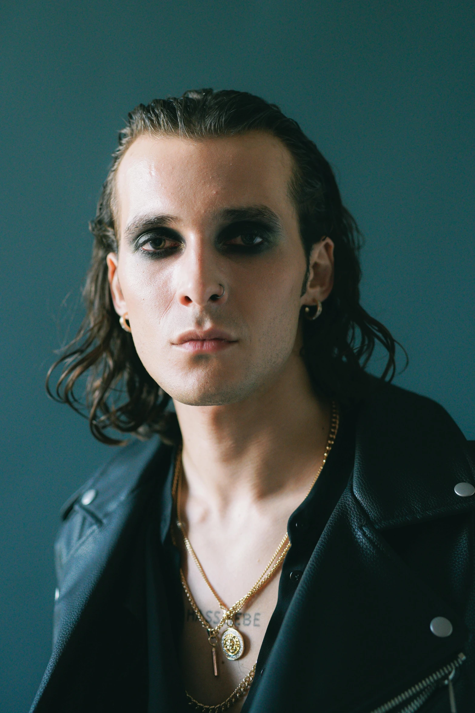 a man with long hair wearing a leather jacket, an album cover, by Winona Nelson, trending on pexels, bauhaus, style of seb mckinnon, charming black eyes, portrait of jerma985, beautiful androgynous prince