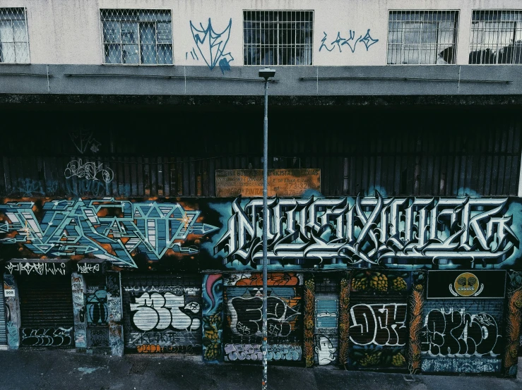 a bunch of graffiti on the side of a building, by Niko Henrichon, pexels contest winner, graffiti, buildings covered in black tar, inside a gang hideout, background image, 90s photo