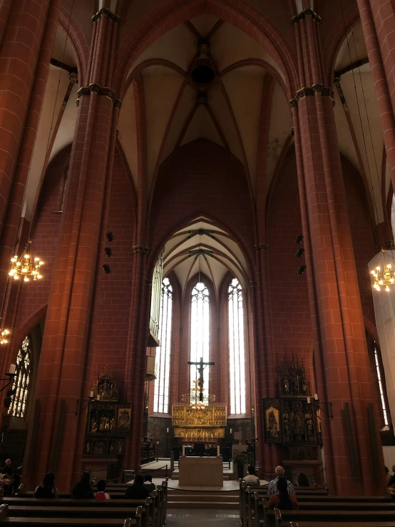 a church filled with wooden pews next to tall windows, a photo, romanesque, in legnica!!!, hannover, low quality photo, red interior