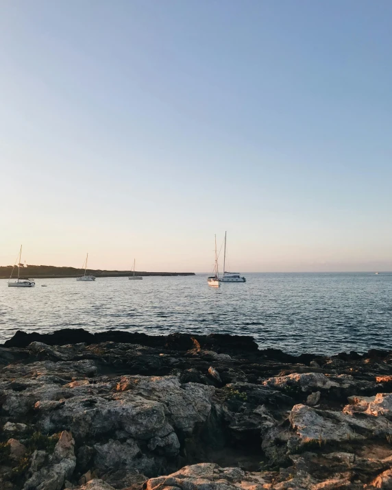 a couple of boats that are in the water, a picture, pexels contest winner, clear skies in the distance, summer evening, med bay, low quality photo