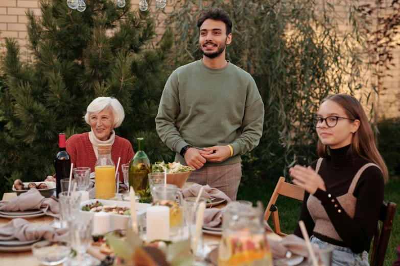 a group of people sitting around a dinner table, in the garden, profile image, proud looking, avatar image