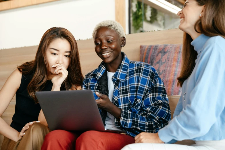 a group of people sitting on a couch looking at a laptop, trending on pexels, three women, ethnicity : japanese, background image, schools