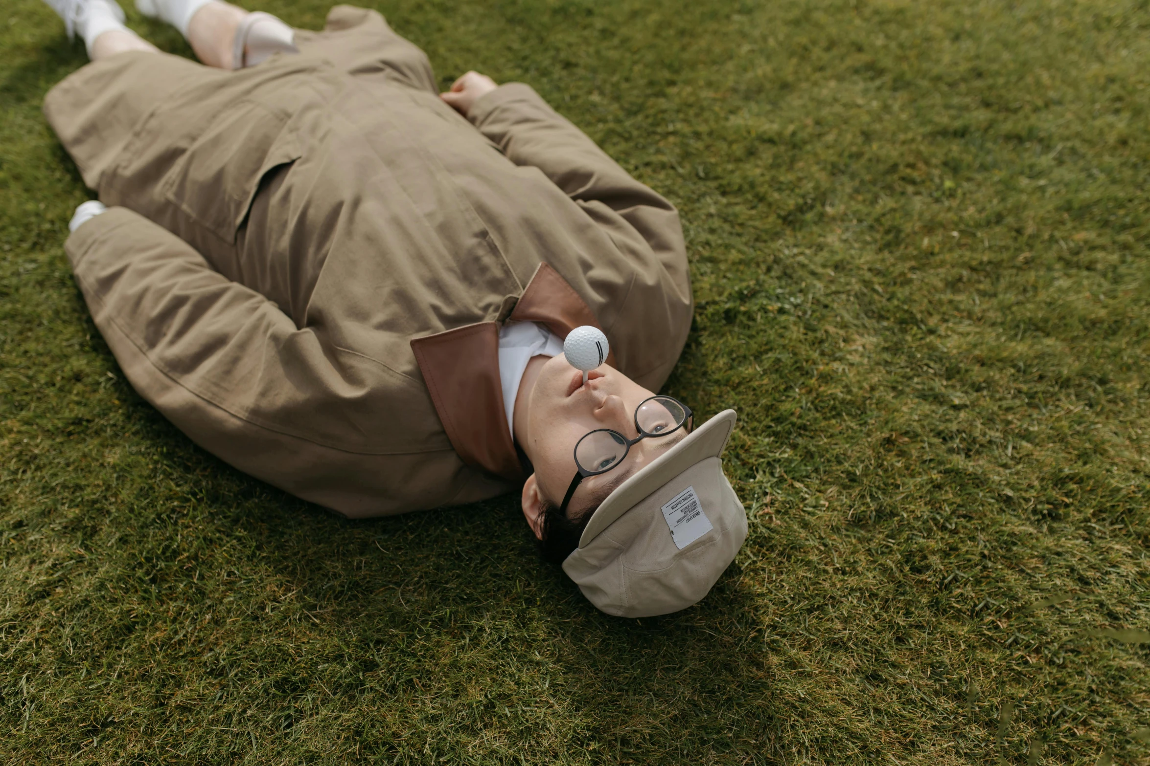 a man laying on top of a lush green field, inspired by Joseph Beuys, unsplash, wearing a monocle, realistic cosplay, sangsoo jeong, peter griffin in real life