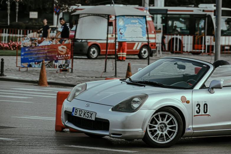 a silver sports car driving down a street, by Adam Marczyński, reddit, les automatistes, rally driving photo, square, russian and japanese mix, white red