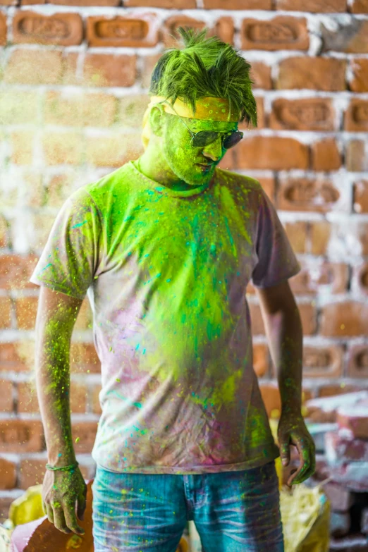 a man standing in front of a brick wall covered in green paint, multiple colors, covered in white flour, wearing a shirt, (neon colors)