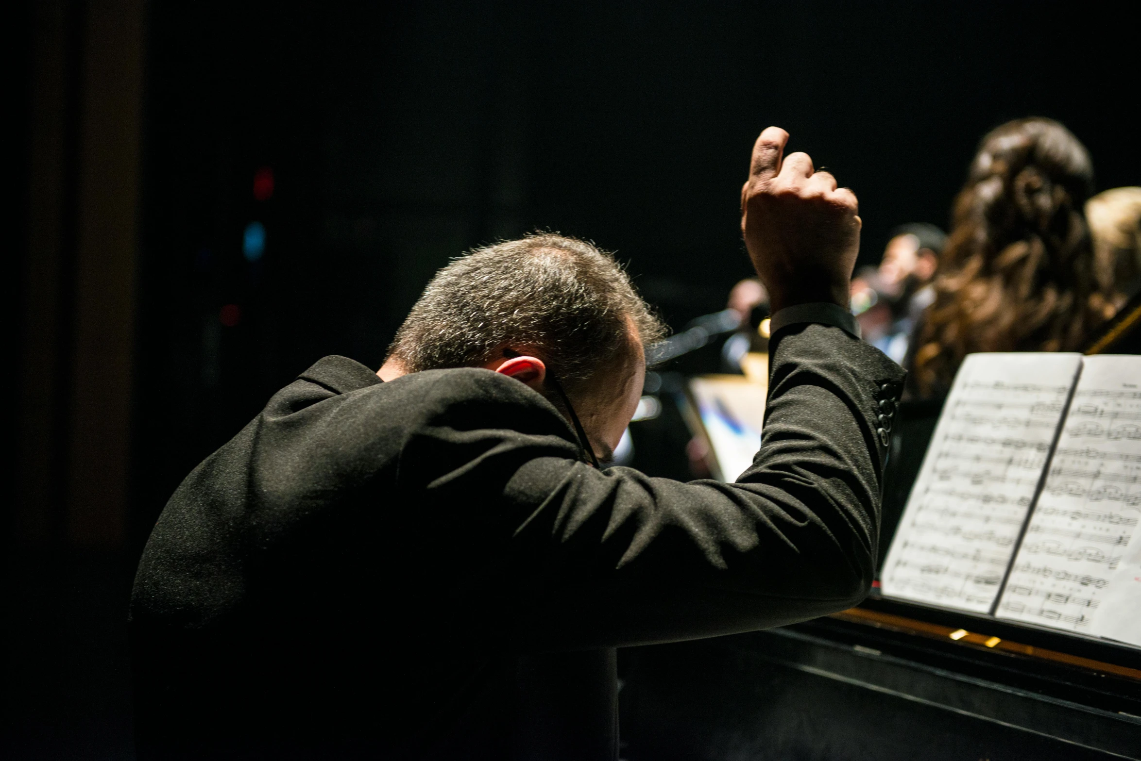 a man that is sitting in front of a piano, unsplash, conductor, head bowed slightly, arms raised, profile image