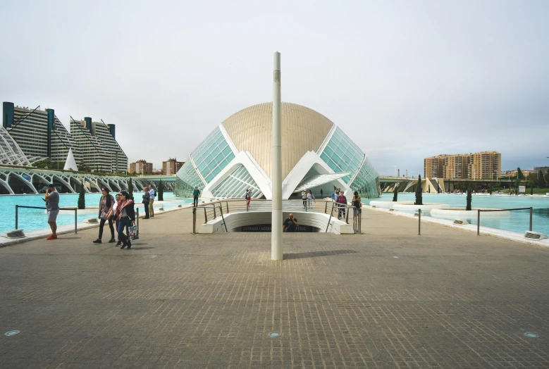 a group of people standing in front of a building, inspired by Francisco Zúñiga, pexels contest winner, modernism, calatrava, seaside, entrance, in the center of the image