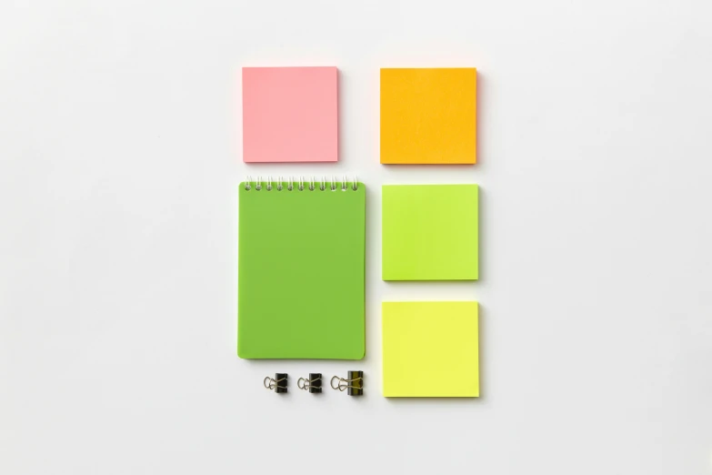 a notepad sitting on top of a white table, 6 colors, neon green, set pieces, square