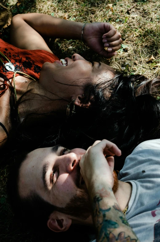 a man and a woman laying in the grass, by Elsa Bleda, reddit, looking down on the camera, promo still, festivals, dan eder