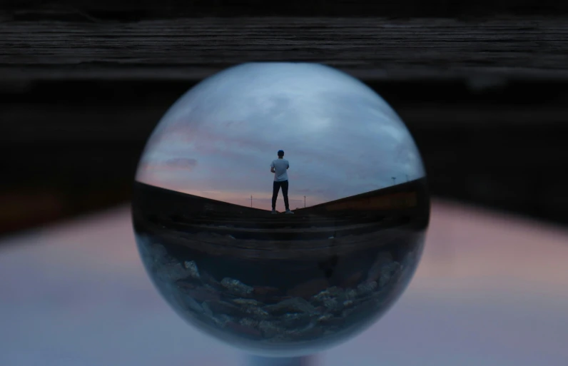 a man standing in front of a mirror with a sky in the background, inspired by Filip Hodas, pexels contest winner, inside glass orb, ilustration, instagram picture, a high angle shot