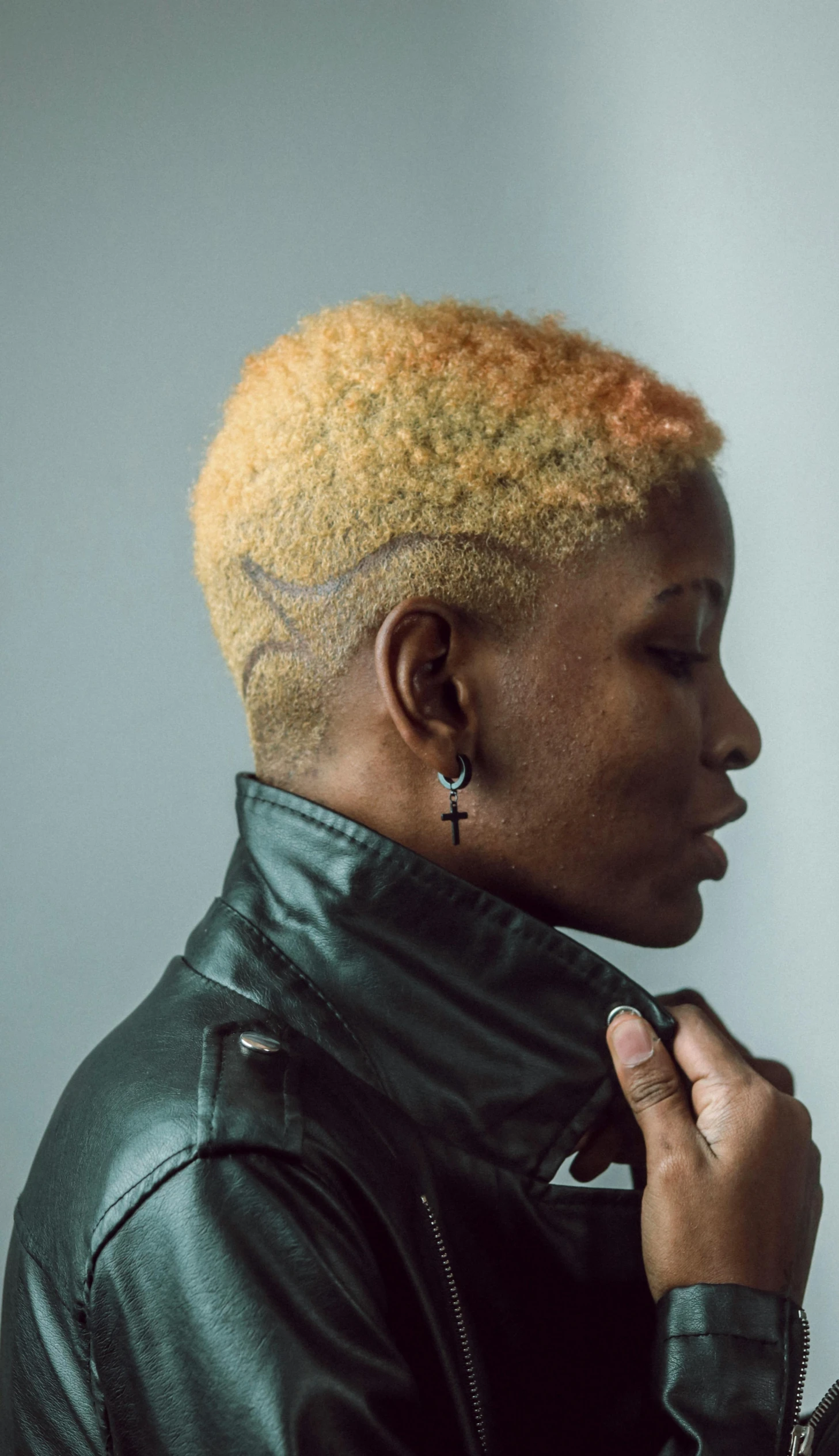 a close up of a person wearing a leather jacket, afrofuturism, light yellow hair, undercut haircut, style of mary jackson, profile image