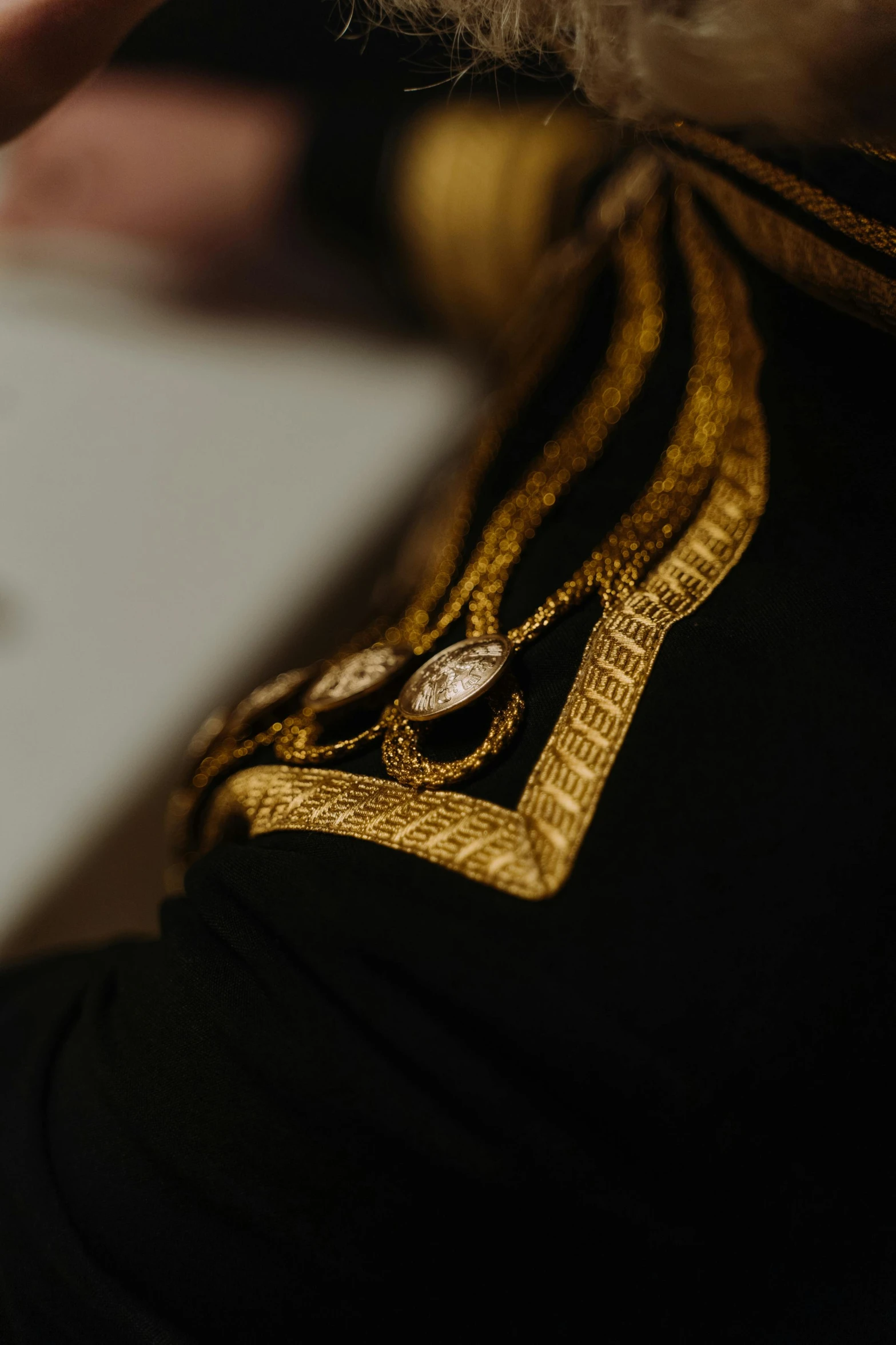 a close up of a person using a cell phone, gilded black uniform, royal cape, shot with sony alpha 1 camera, full dress uniform