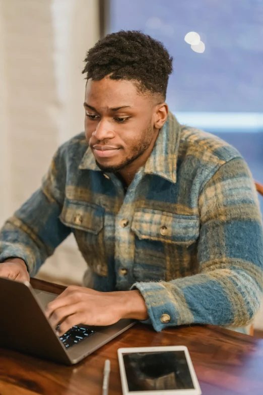 a man sitting at a table using a laptop computer, trending on pexels, renaissance, he is wearing a brown sweater, arik roper, j. h. williams iii, thumbnail