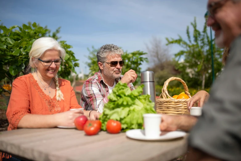 a group of people sitting around a table with vegetables, in the sun, profile image, high resolution photo, avatar image