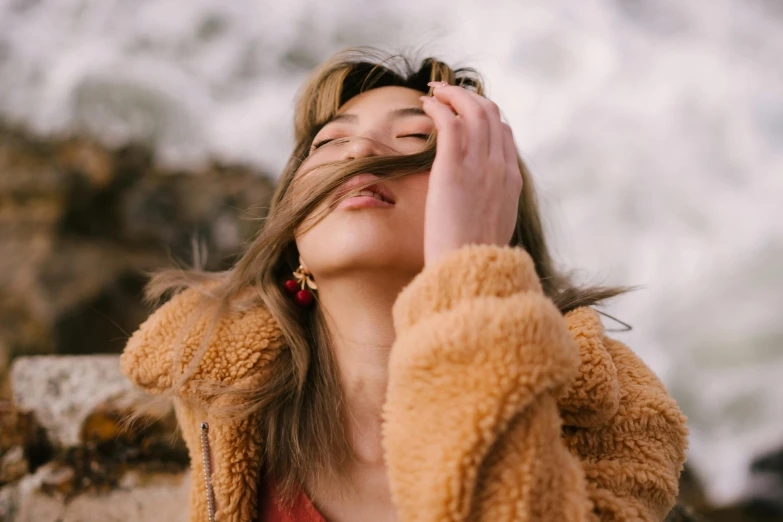 a woman with her hair blowing in the wind, trending on pexels, furry face, pokimane, jacket over bare torso, coral brown hair