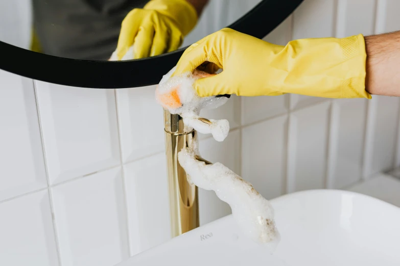 a person in yellow gloves cleaning a bathroom sink, by Julia Pishtar, premium quality, fan favorite, profile image, maintenance photo