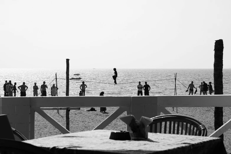 a black and white photo of people on the beach, by Mathias Kollros, pexels contest winner, volley court background, on a birdge, red sea, on a white table
