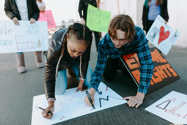 a couple of people that are writing on a piece of paper, protest, on a canva, marking lines, 2019 trending photo