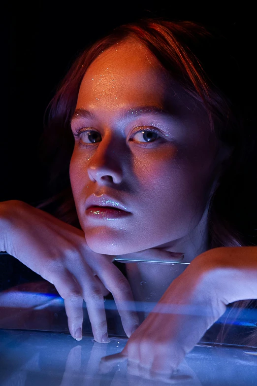 a woman sitting in front of a laptop computer, a portrait, inspired by Nan Goldin, trending on pexels, photorealism, smooth bioluminescent skin, coloured gel studio light, sydney sweeney, on a spaceship