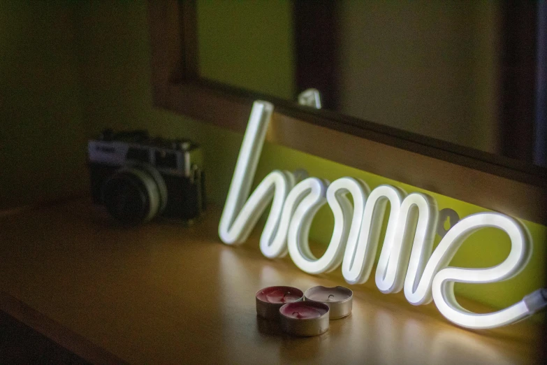 a neon sign sitting on top of a wooden table, a picture, at home, home, lumen reflections, home display