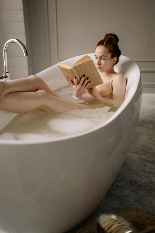 a woman sitting in a bathtub reading a book, sleek curves, qualia, ginger, alternate angle