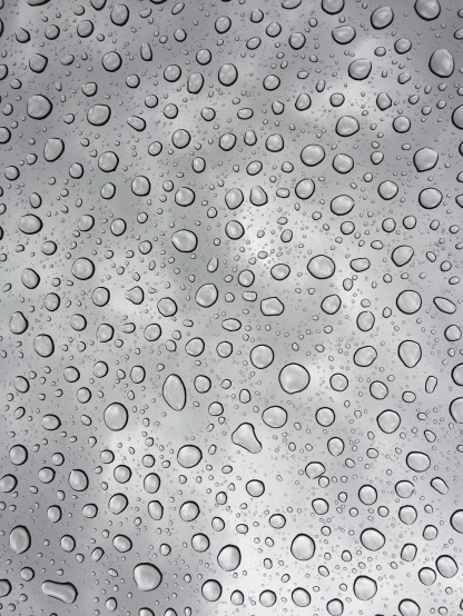 a close up of water droplets on a metal surface, overcast gray skies, conor walton, glass cover, patterned