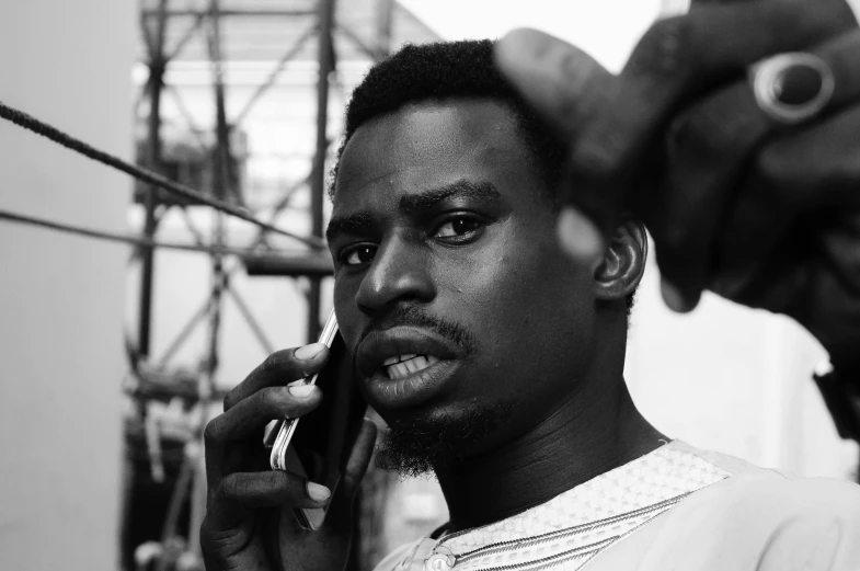 a black and white photo of a man talking on a cell phone, by Chinwe Chukwuogo-Roy, 2 4 - year - old man, multicoloured, ((portrait)), :: morning