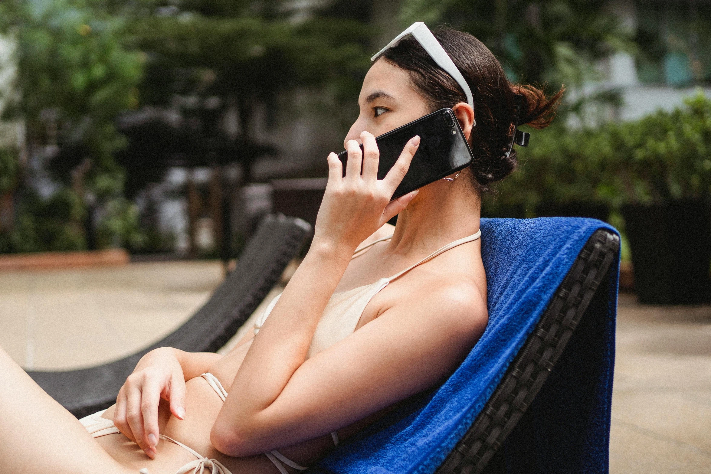 a woman sitting in a chair talking on a cell phone, abandoned scuba visor, sleek cool waterproof design, holiday vibe, silicone skin