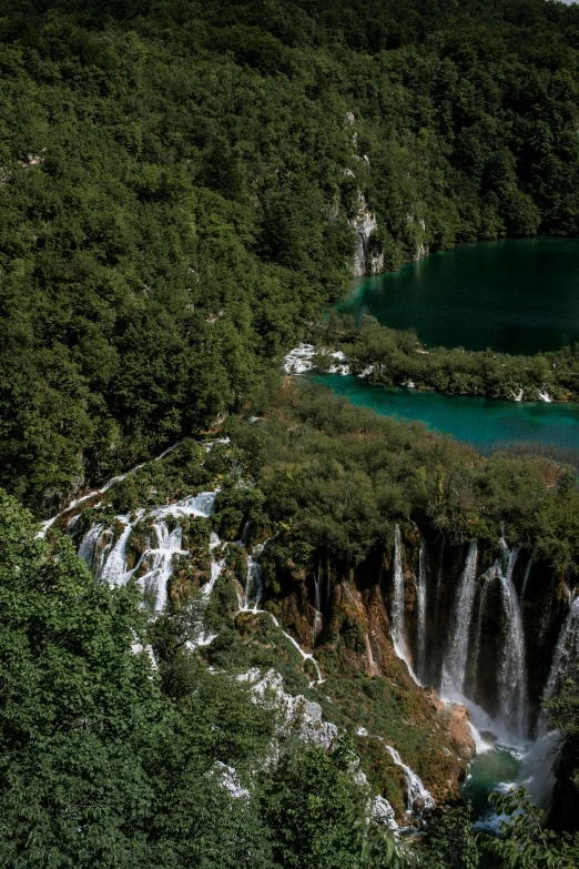 a large waterfall in the middle of a lush green forest, croatian coastline, lakes, brilliantly coloured, exterior