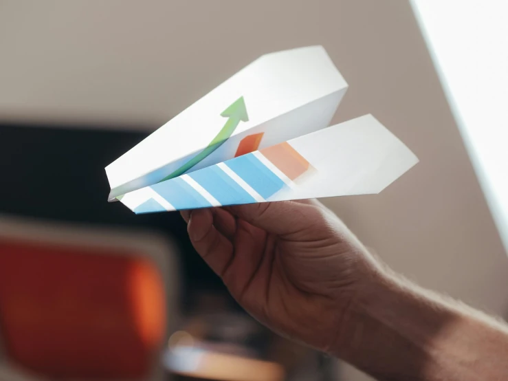 a person holding a paper airplane in their hand, pexels contest winner, charts, 3d printed, thumbnail, middle shot