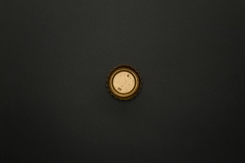 a close up of a clock on a black surface, an album cover, by Adam Chmielowski, unsplash, conceptual art, beer bottle, gold, ffffound, very minimalistic