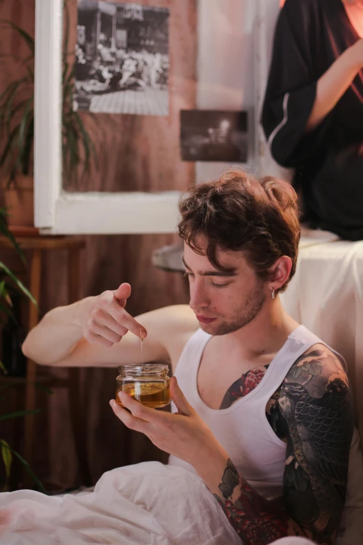 a man sitting on top of a bed next to a woman, a tattoo, by Jessie Alexandra Dick, trending on reddit, cooking oil, inside a glass jar, ignant, thc