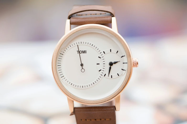 a close up of a wrist watch on a table, inspired by Kōno Michisei, tumblr, rose gold, jovial, both faces visible, tom