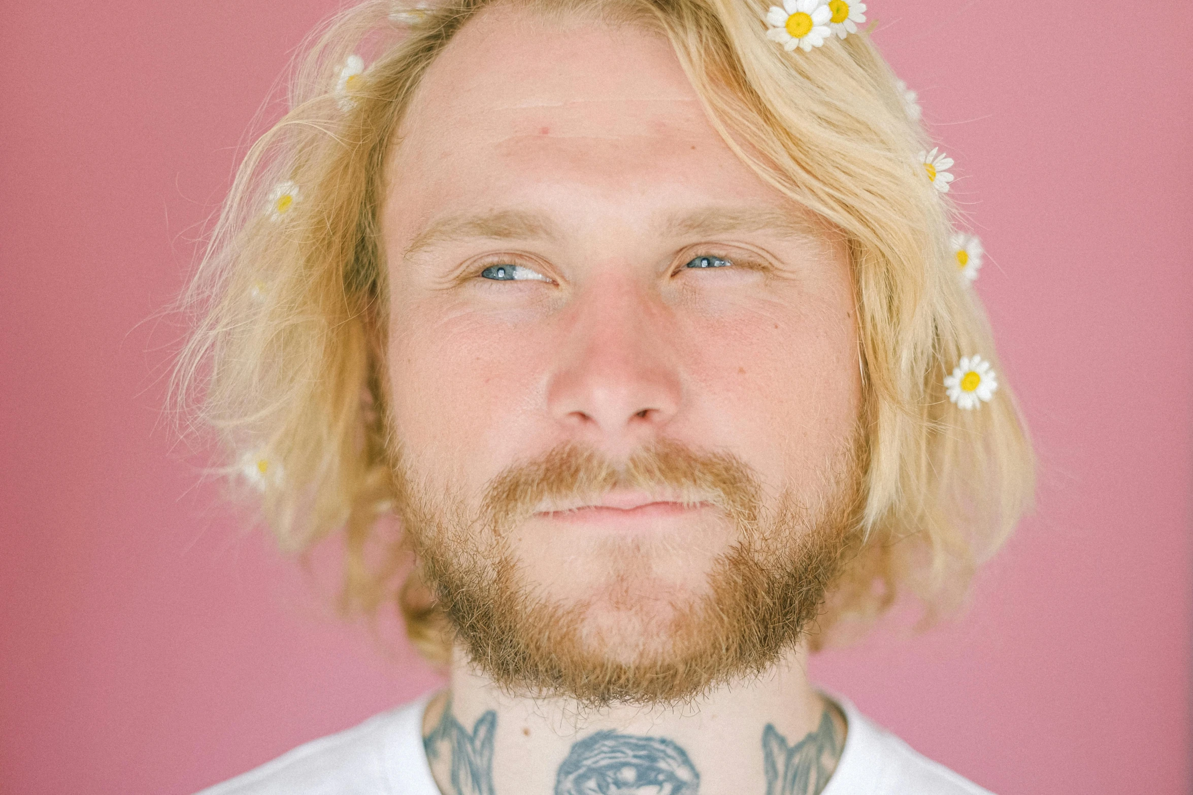 a man with a flower in his hair, an album cover, by Lasar Segall, trending on pexels, small blond goatee, face tattoo, white freckles, devon cady-lee