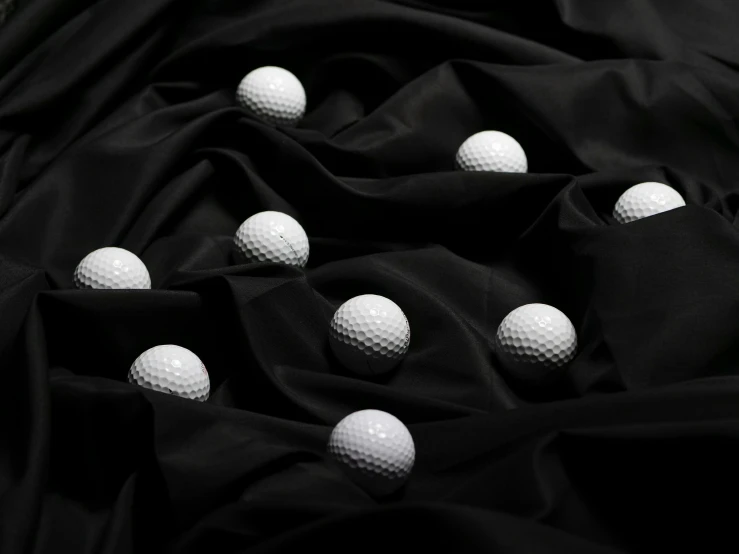 a pile of golf balls sitting on top of a black cloth, by irakli nadar, carved marble texture silk cloth, product introduction photo, uniform background, vantablack gi