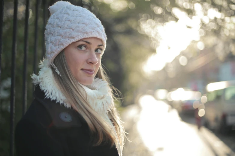 a woman wearing a white hat and scarf, inspired by Caroline Lucy Scott, pexels, beautiful soft lighting, street pic, pink, winter sun