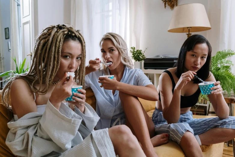 three women sitting on a couch eating food, by Matija Jama, trending on pexels, happening, yogurt, sydney sweeney, offering the viewer a pill, bong
