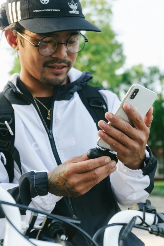 a man on a motorcycle looking at his cell phone, trending on pexels, a man wearing a backpack, holding a small vape, loish and ross tran, holding a pocket watch