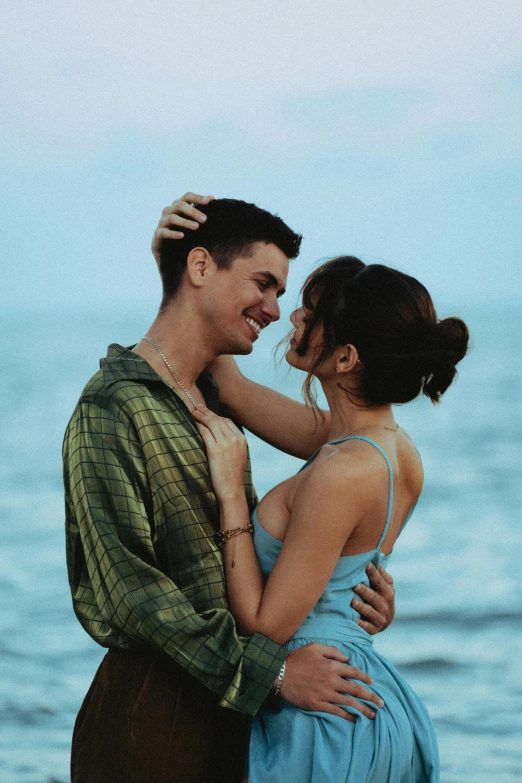 a man and woman standing next to each other on a beach, teal aesthetic, pretty woman, julian ope, excited